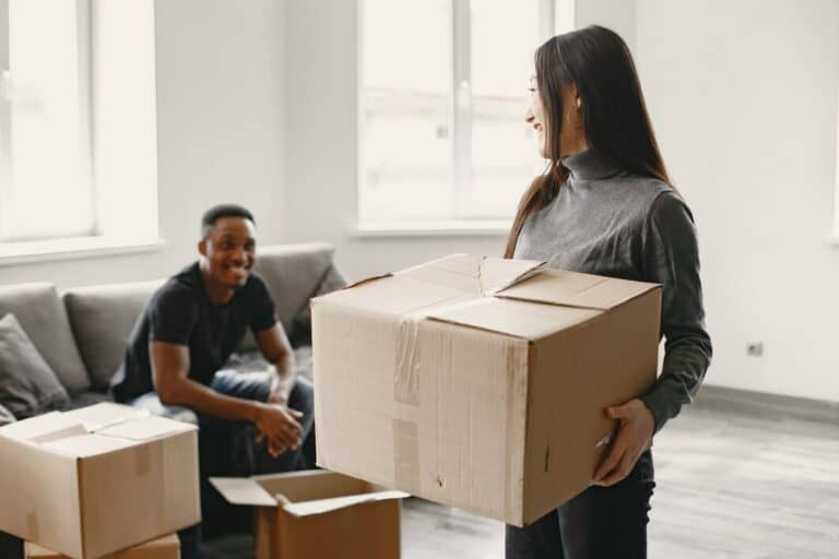 Happy movers packing boxes in a modern apartment
