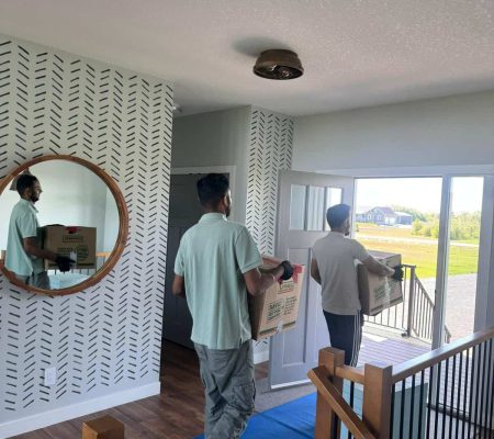 Movers Carrying Packed Household Boxes Through Doorway